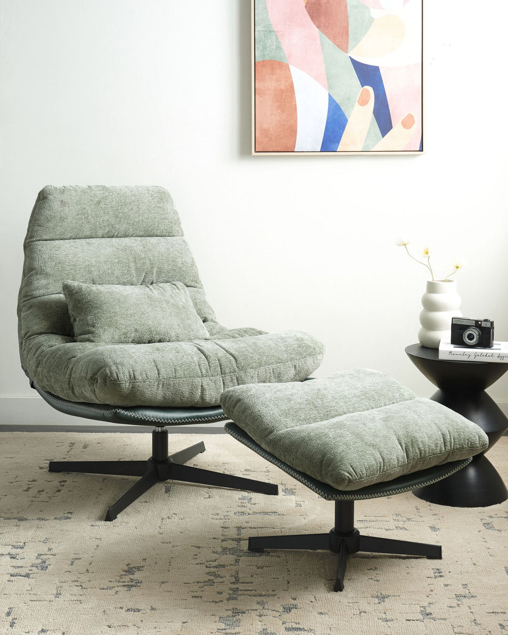 A light green, mid-century style swivel armchair with a curved seat and foam padding, mounted on a black metal base, positioned in a well-lit living room next to a stool with a decorative vase.