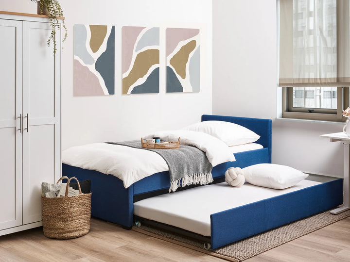 Blue bed with white bedding in a modern bedroom setting.
