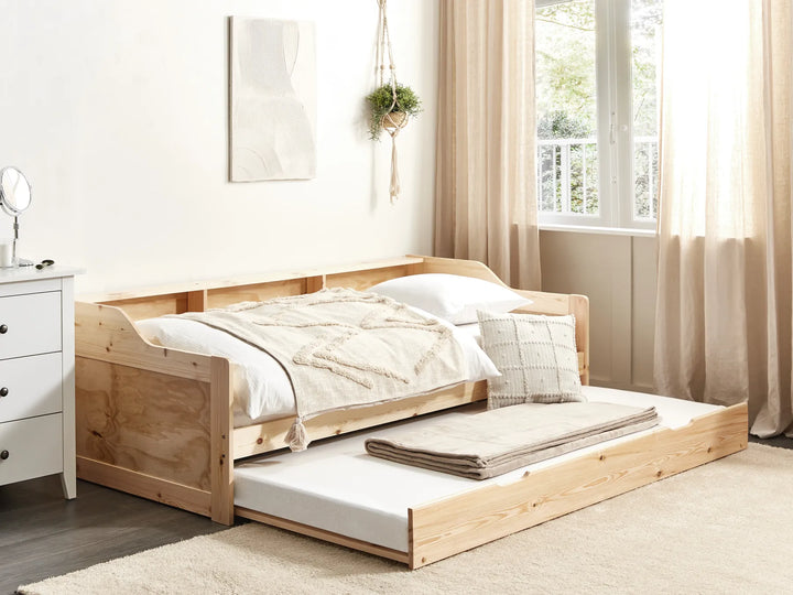 Wooden bed with pull-out trundle in a bright bedroom