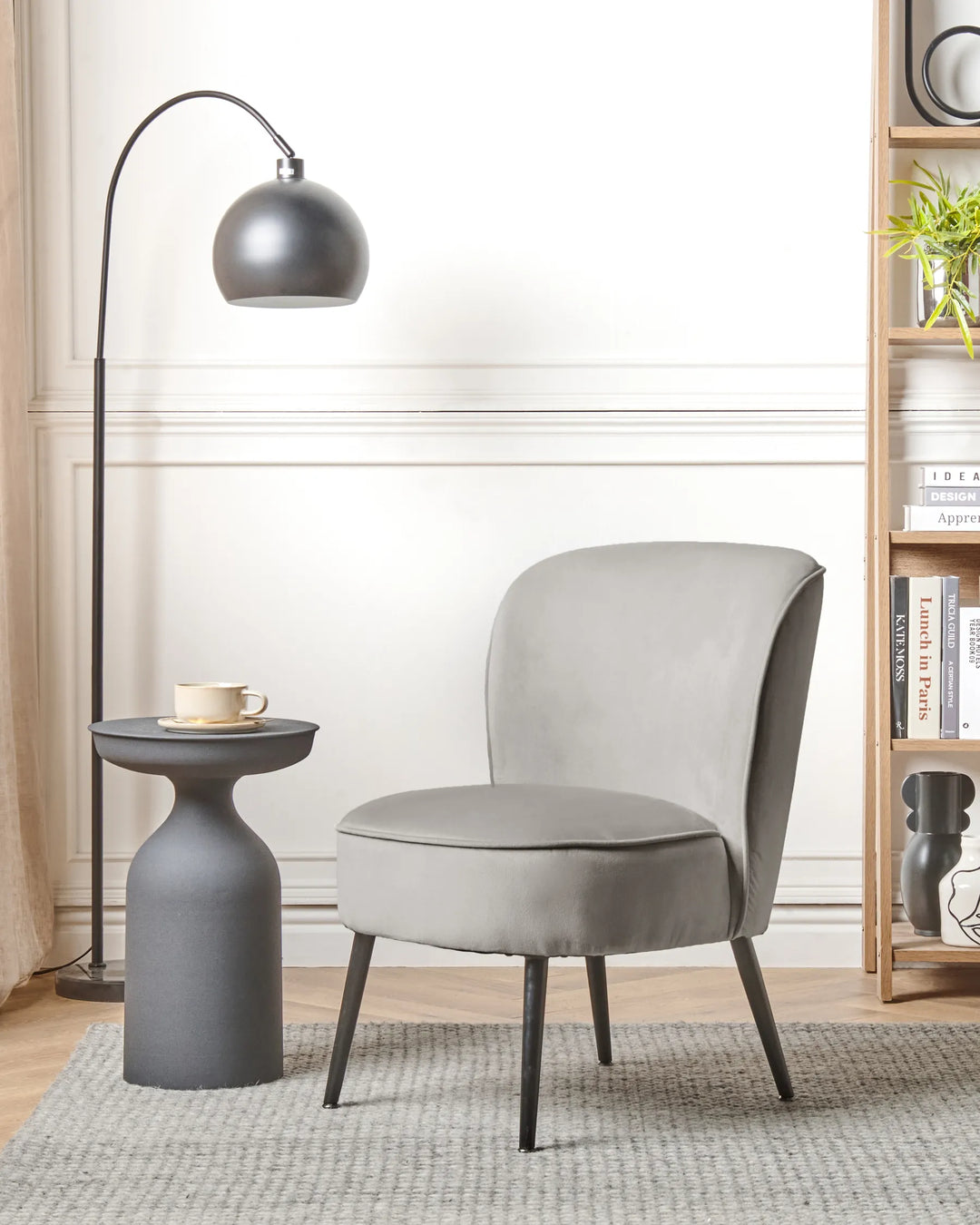 Gray chair in a modern living room with a side table and floor lamp.