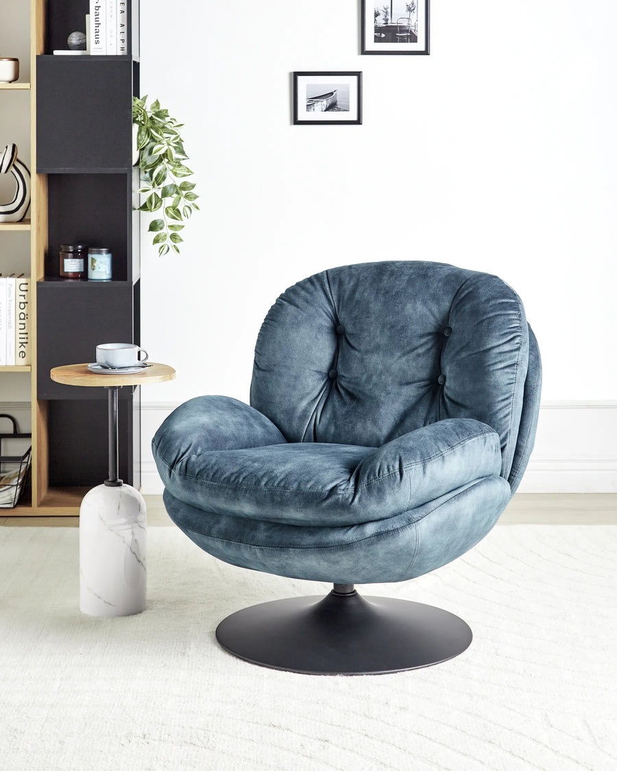 Blue armchair in a room with a bookshelf, side table, and decorative items.