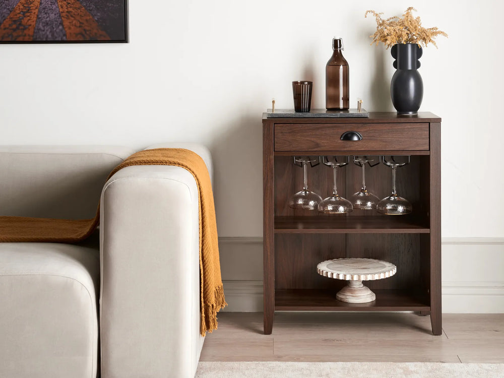 Wooden sideboard with wine glasses and bottles in a living room setting