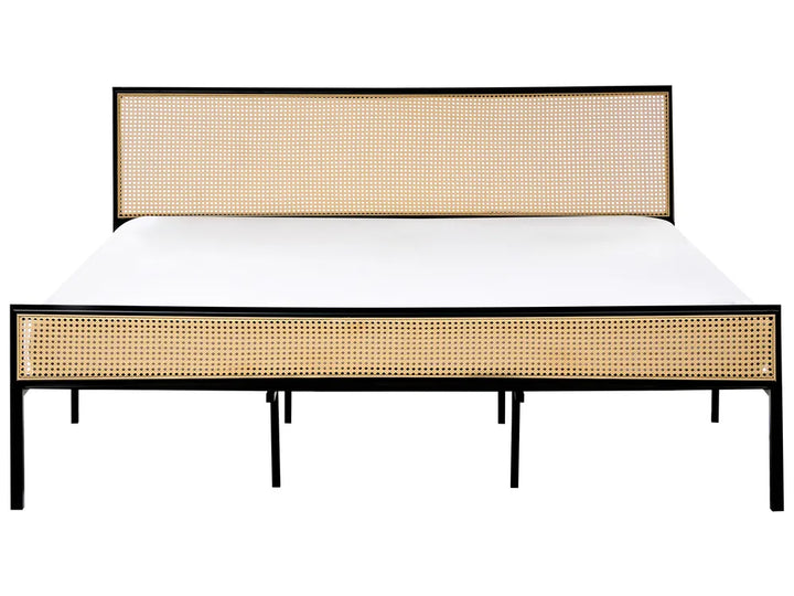 Bed with rattan headboard and footboard on a white background