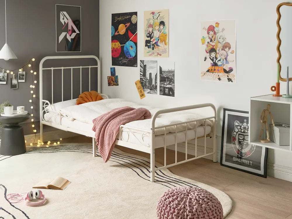 Children's bedroom with a bed, posters on the wall, and decorative items.