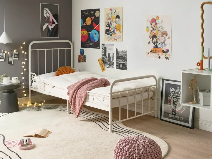Children's bedroom with a bed, posters on the wall, and decorative items.