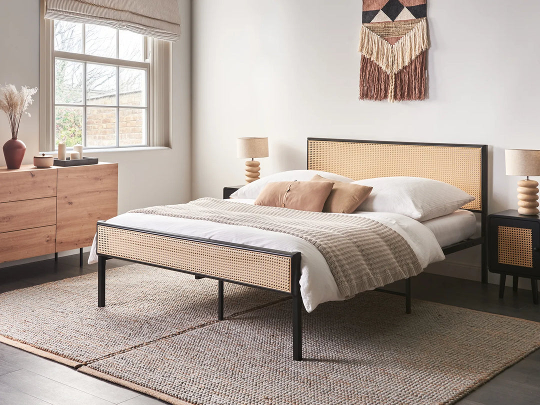 Bedroom with a bed featuring a woven headboard and nightstands with lamps.