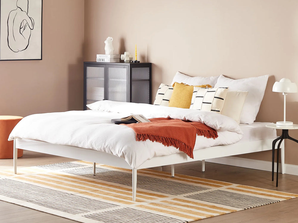 Modern bedroom with a bed, nightstands, and decorative items.