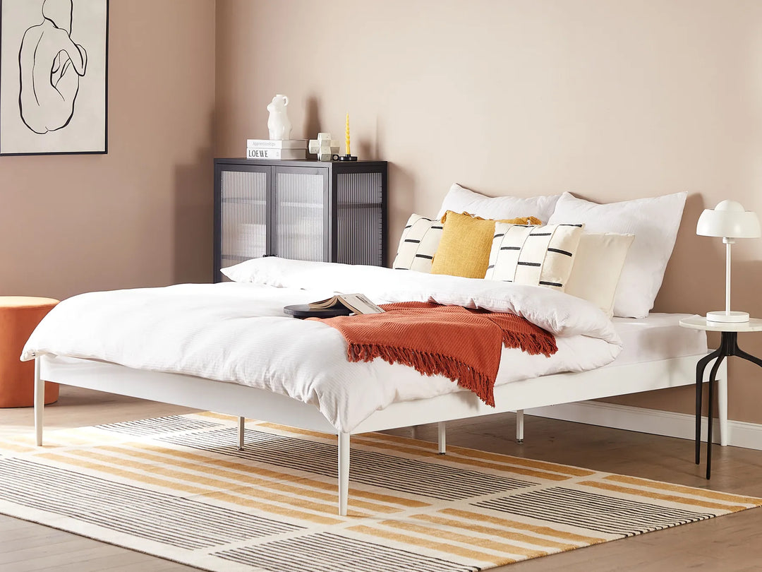 Modern bedroom with a bed, nightstands, and decorative items.
