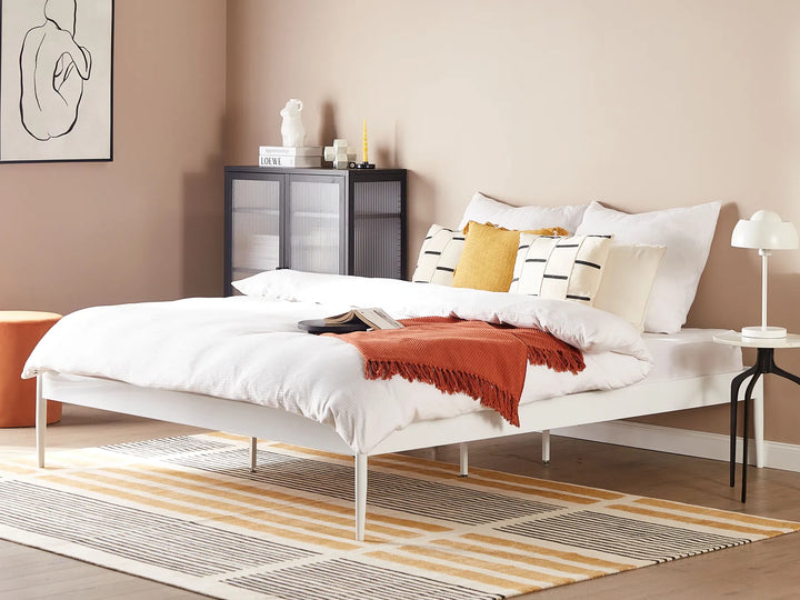 Modern bedroom with a bed, nightstands, and decorative items.