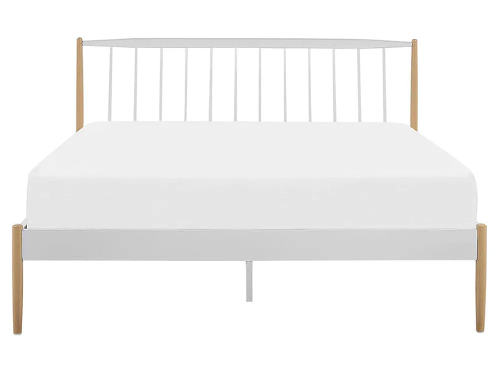 Bed with white mattress and metal frame on a white background