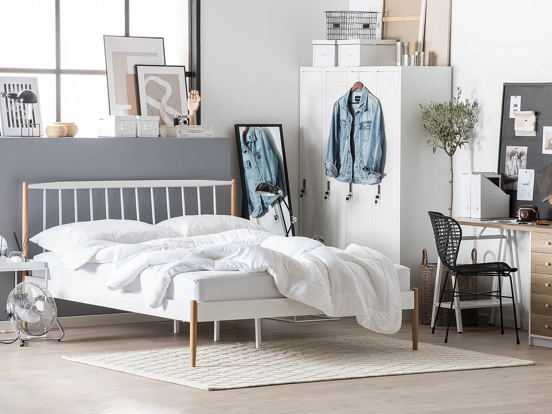 Modern bedroom with a bed, desk, and various decor items.