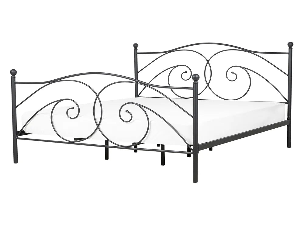 Decorative metal bed frame with intricate designs on a white background