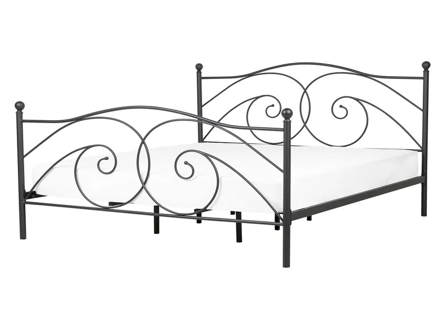 Decorative metal bed frame with intricate designs on a white background