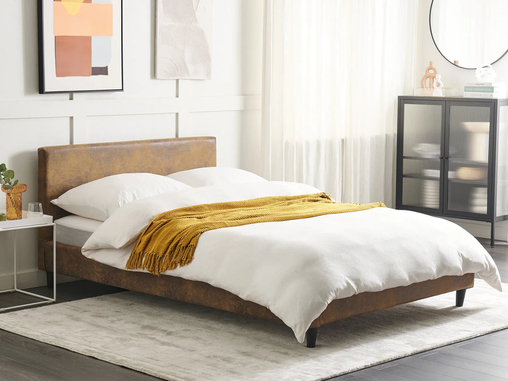 Bedroom with a wooden bed frame, white bedding, and a yellow blanket.