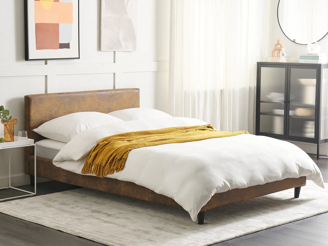 Bedroom with a wooden bed frame, white bedding, and a yellow blanket.