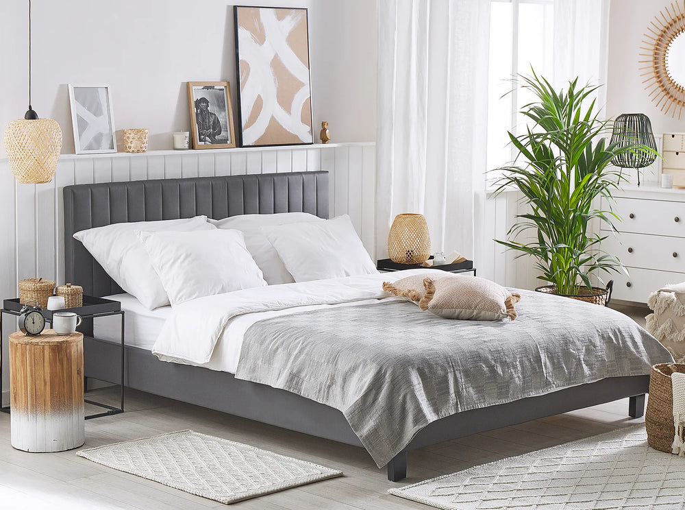 Modern bedroom with a gray upholstered bed, white bedding, and decorative elements.