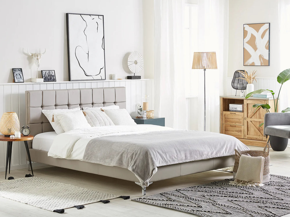 Modern bedroom with a gray upholstered bed, wooden side table, and decorative items.