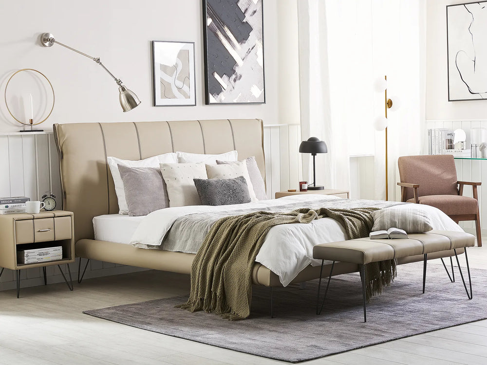 Modern bedroom with a beige upholstered bed, side tables, and decor.
