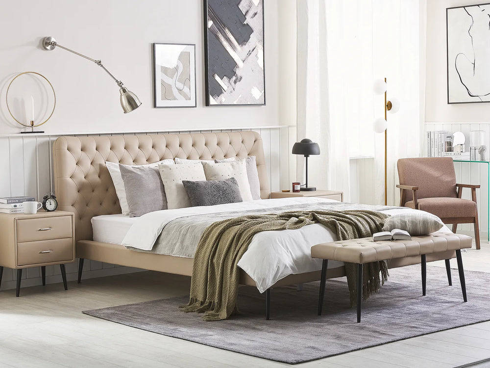 Modern bedroom with beige upholstered bed, armchair, and decor elements.