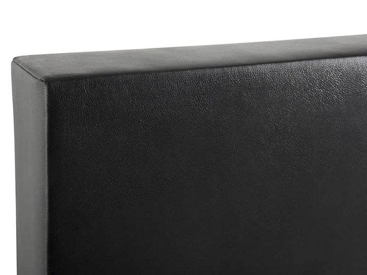 Close-up of a black upholstered headboard corner on a white background