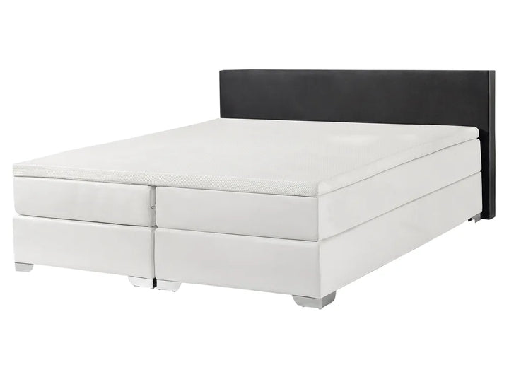 White bed with black headboard on a white background