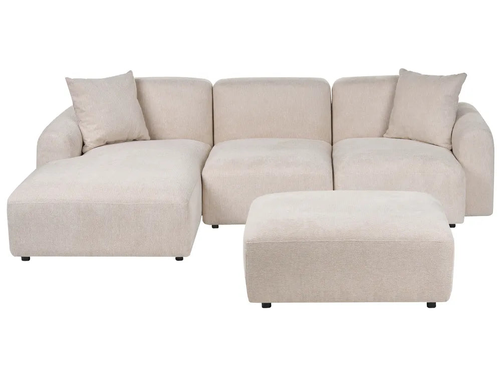 A light beige fabric sectional sofa with a chaise lounge on the left and a matching rectangular ottoman, shown against a plain white background.