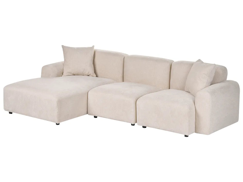 A modern sectional sofa in a light beige fabric, featuring a left-facing chaise lounge, three back cushions, and two loose throw pillows, shown against a plain white background.