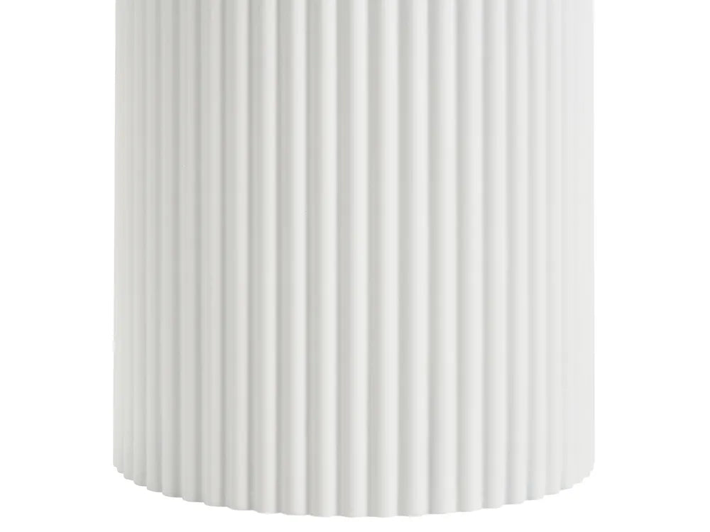 A close-up of a white cylindrical product with vertical fluted ridges, shown against a plain white background.