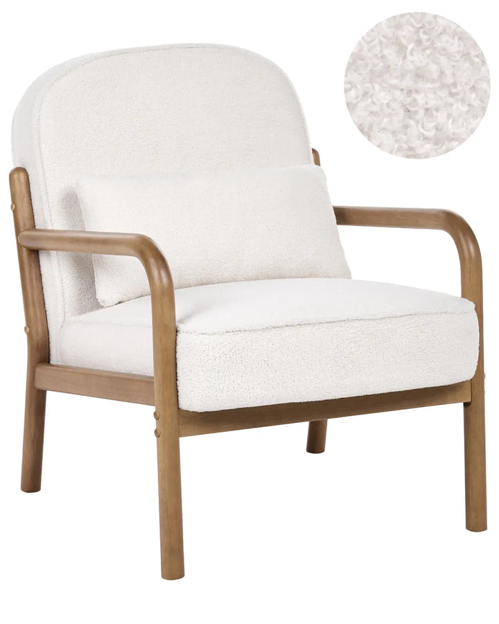 A modern armchair with a warm brown wooden frame and plush off-white bouclé upholstery, shown on a plain white background with a circular fabric close-up inset in the top right.