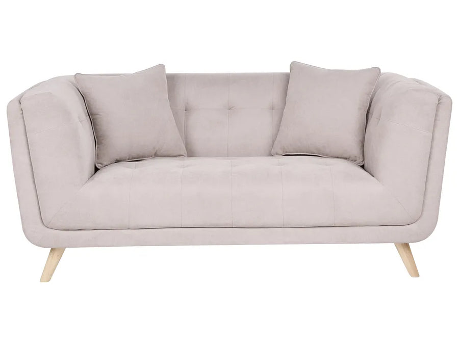 A light beige upholstered loveseat with two matching throw pillows and light wood legs, shown against a plain white background.