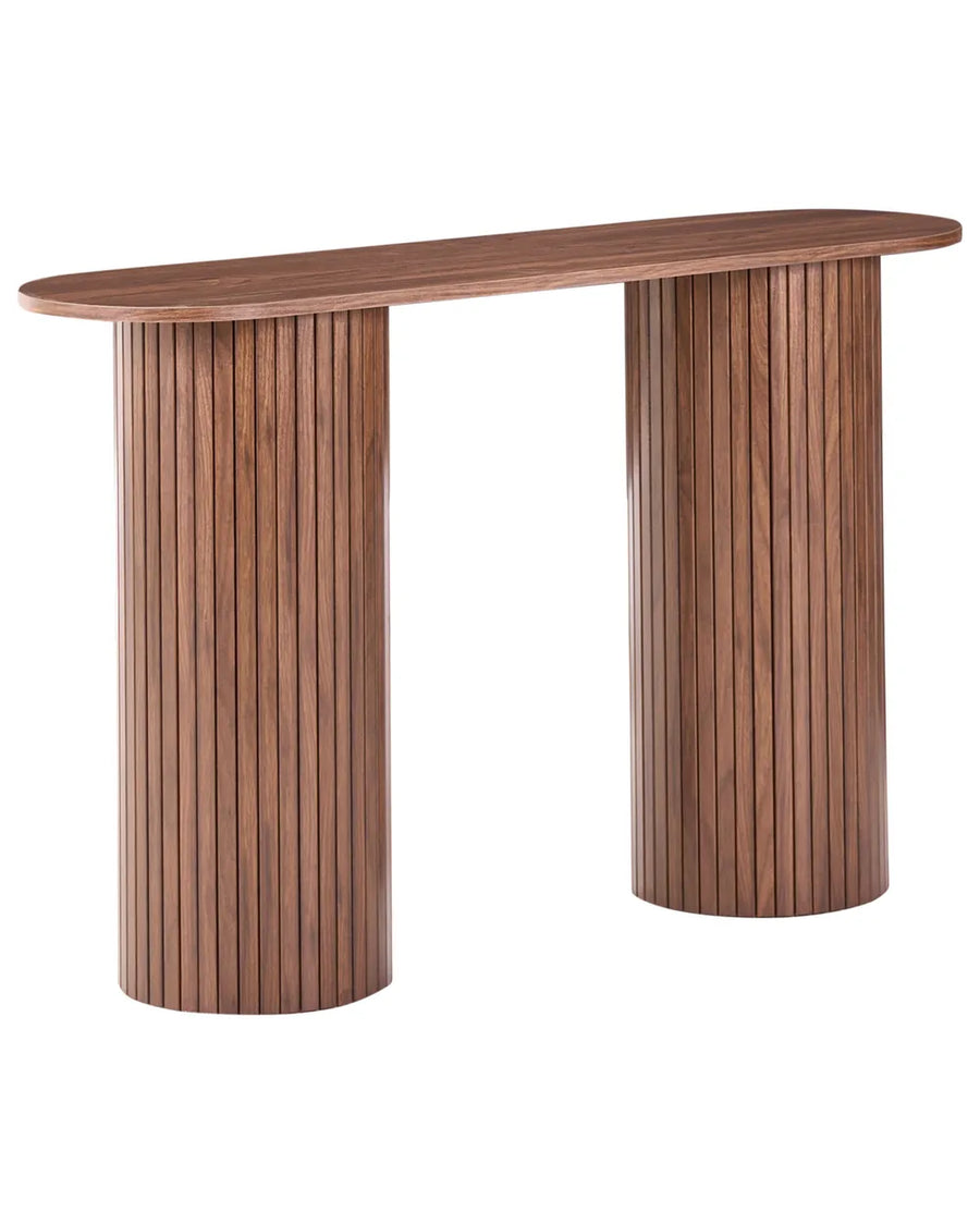 A modern wooden console table featuring a rounded, elongated oval top and two fluted cylindrical pedestal legs in a warm medium brown wood finish, shown on a solid white background.