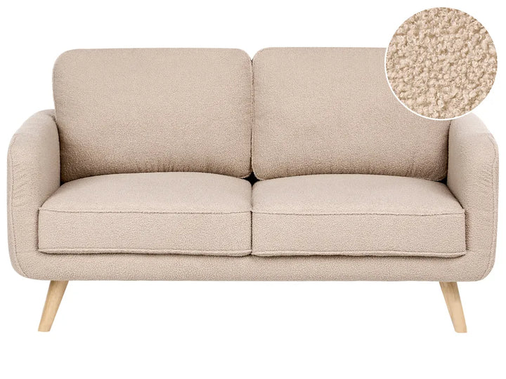 A two-seat upholstered sofa in a warm beige bouclé fabric with light wood legs, shown on a plain white background with a circular fabric close-up inset in the top right.