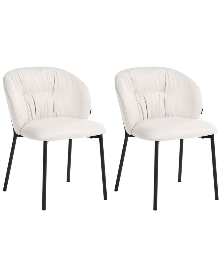 Two modern dining chairs with cream-colored upholstered seats and curved backs, supported by slim black metal legs, shown against a plain white background.