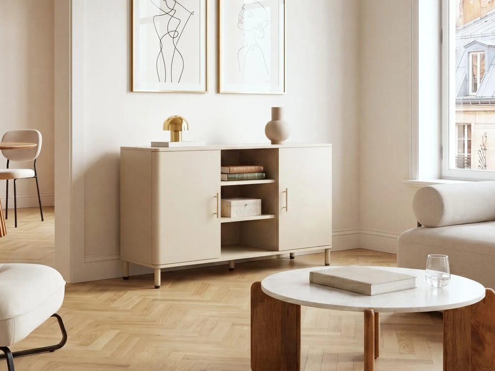 A modern beige sideboard cabinet with open doors and shelves, styled in a bright, minimalist living room with light wood floors, a white coffee table, and neutral decor.