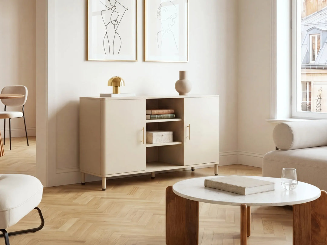A modern beige sideboard cabinet with open doors and shelves, styled in a bright, minimalist living room with light wood floors, a white coffee table, and neutral decor.
