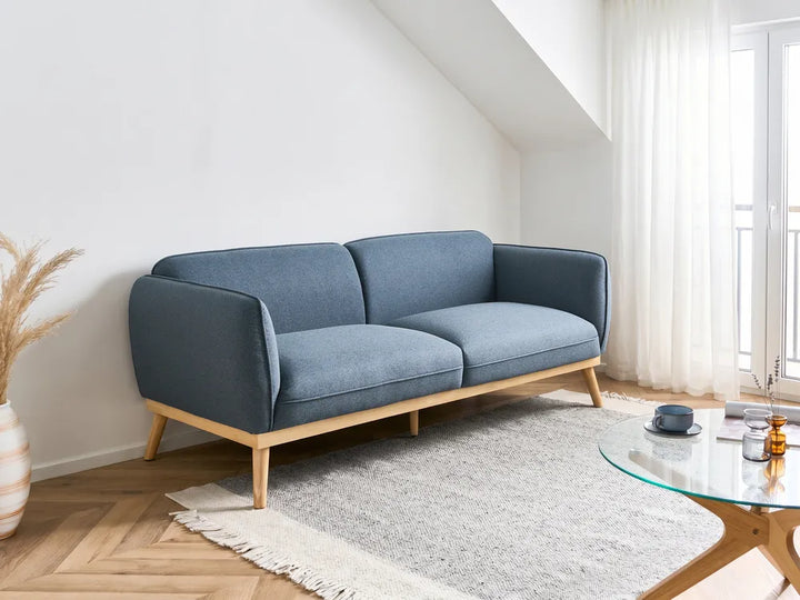 Blue sofa in a living room with a coffee table and decorative items.
