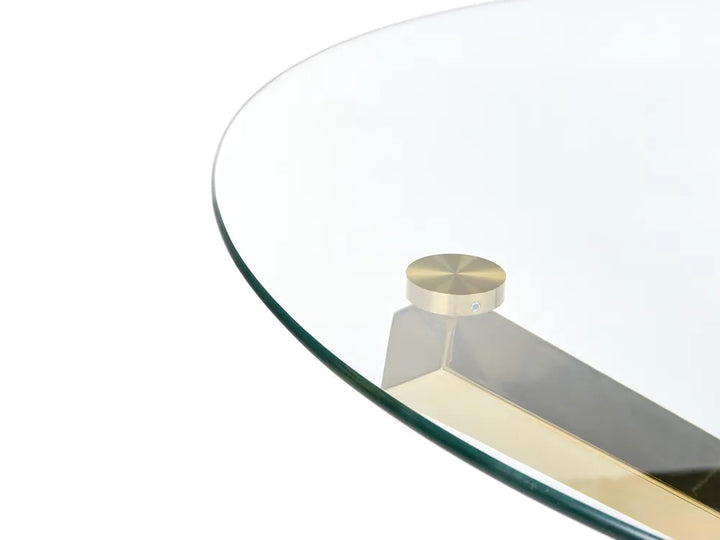Close-up of a modern round glass table top with a brushed brass or gold metal pedestal base and a matching round finial, shown on a white background.