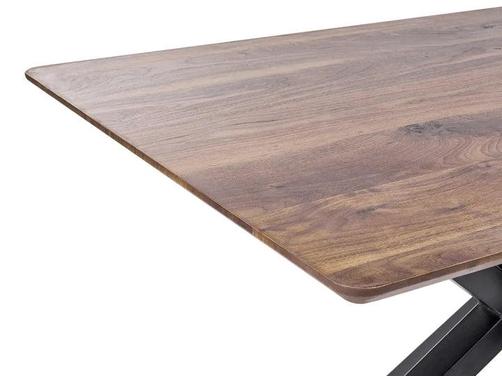 Close-up of a rectangular wooden table with rounded corners and a dark metal base leg, shown on a white background.