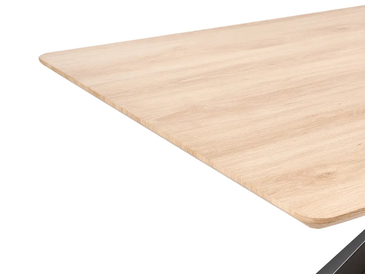Close-up of a light natural wood tabletop corner with rounded edges on a white background.