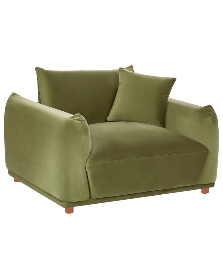 An olive green velvet armchair with two matching throw pillows and small reddish-brown wooden legs, shown against a plain white background.