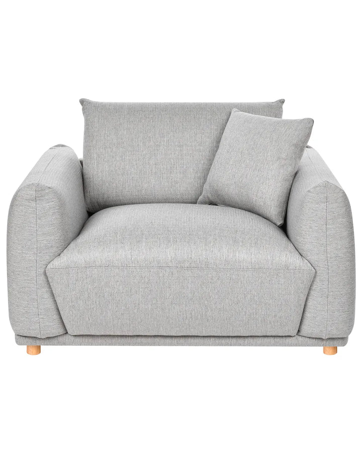 A light gray upholstered armchair with a matching throw pillow and small wooden legs, shown against a plain white background.
