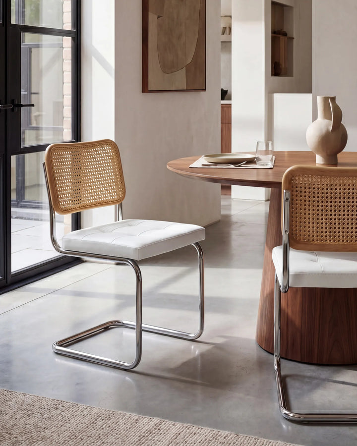 Dining area with modern chairs and a table in a well-lit room.