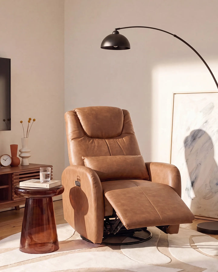 A tan leather recliner chair with the footrest extended, styled in a modern living room setting next to a translucent amber side table and a black floor lamp.