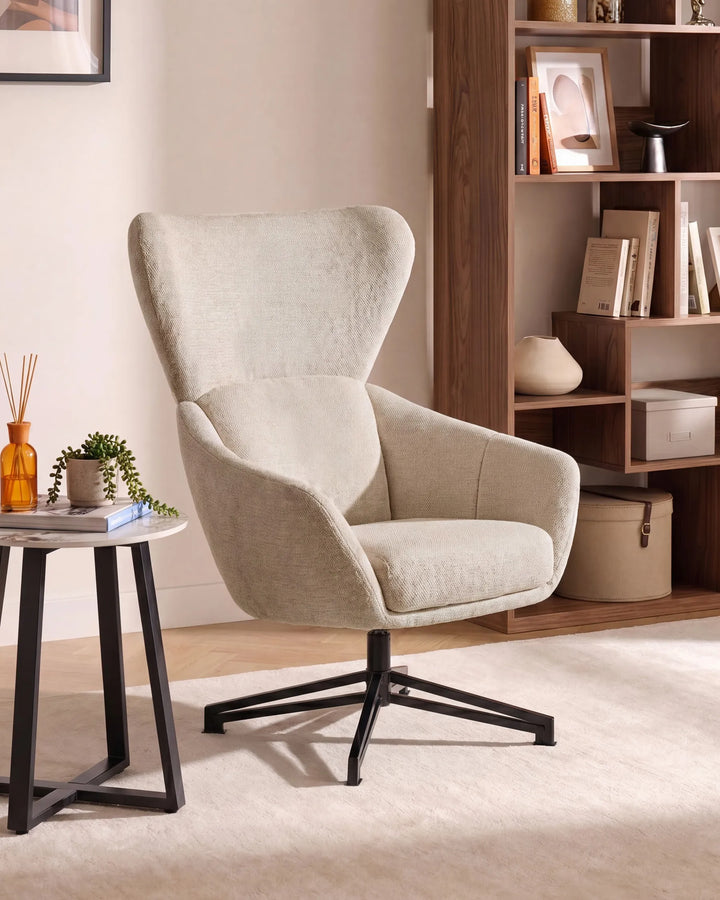 Beige armchair in a room with a bookshelf and small table.