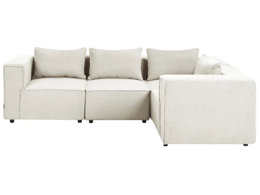 A modern modular sectional sofa upholstered in a textured light beige fabric, featuring three back cushions and a right-facing chaise lounge, shown against a plain white background.