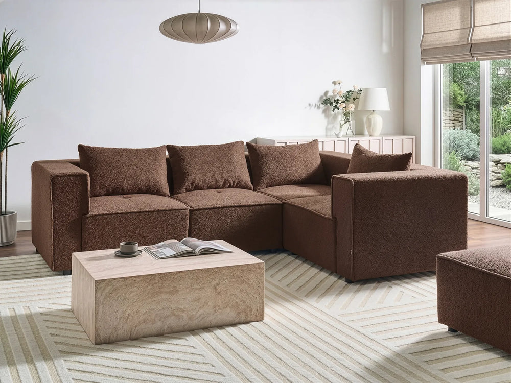 Brown sectional sofa in a living room with a coffee table and decor items.