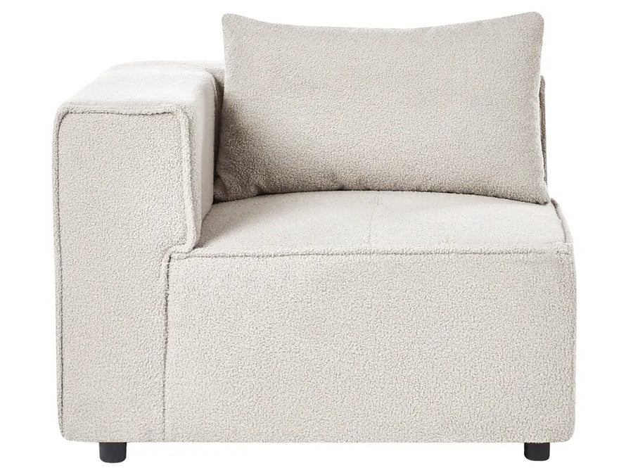 A modern low-profile accent chair upholstered in a textured bouclé fabric in a light oatmeal beige color, featuring a square back cushion and small dark feet, shown against a plain white background.