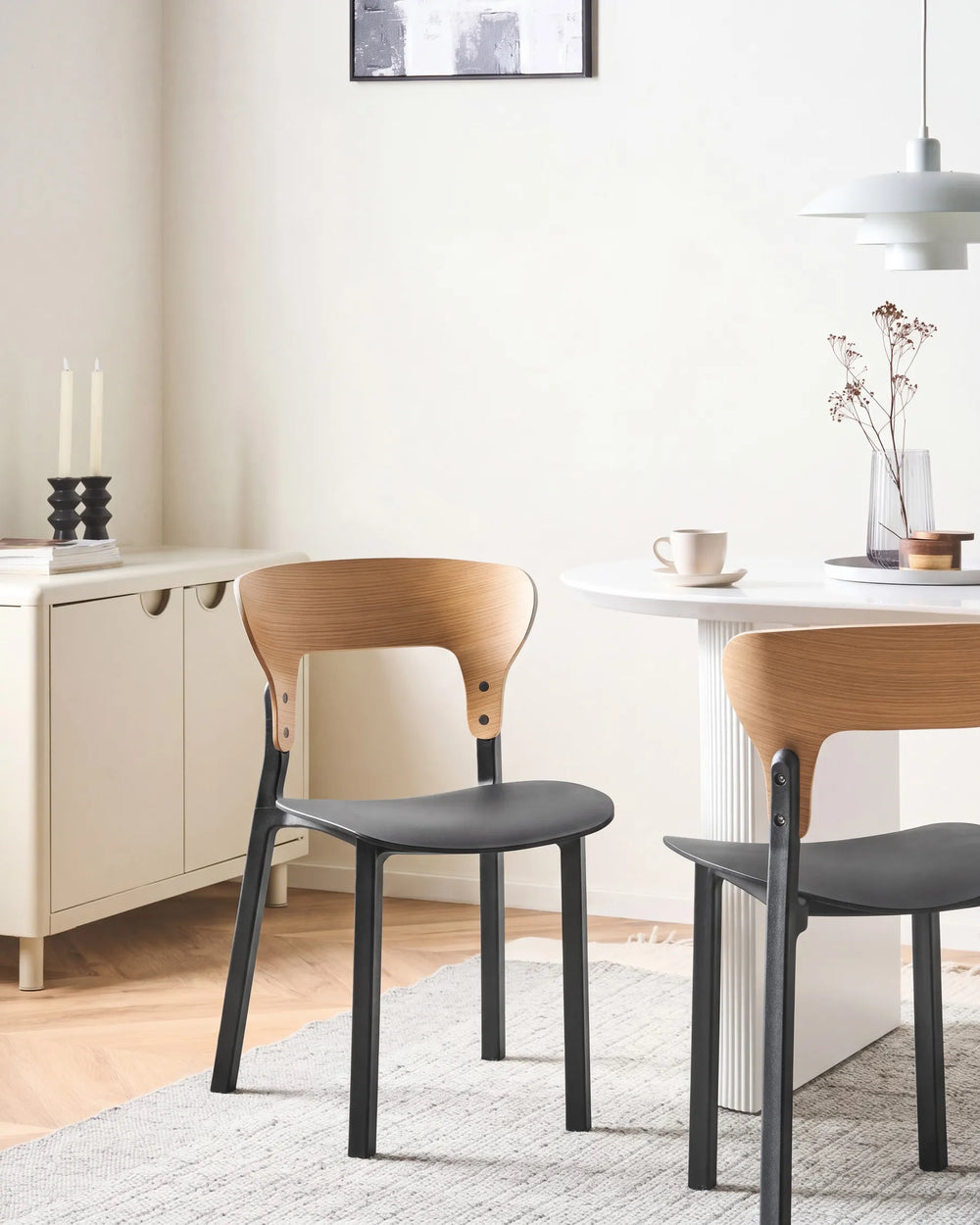 Dining room with wooden chairs and a table, featuring a neutral color palette.