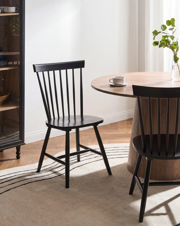 Dining room with black chairs and a wooden table.