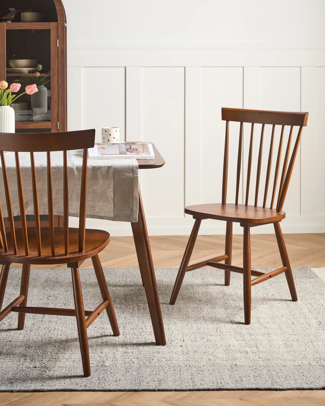 Wooden dining chairs around a table with a neutral decor background